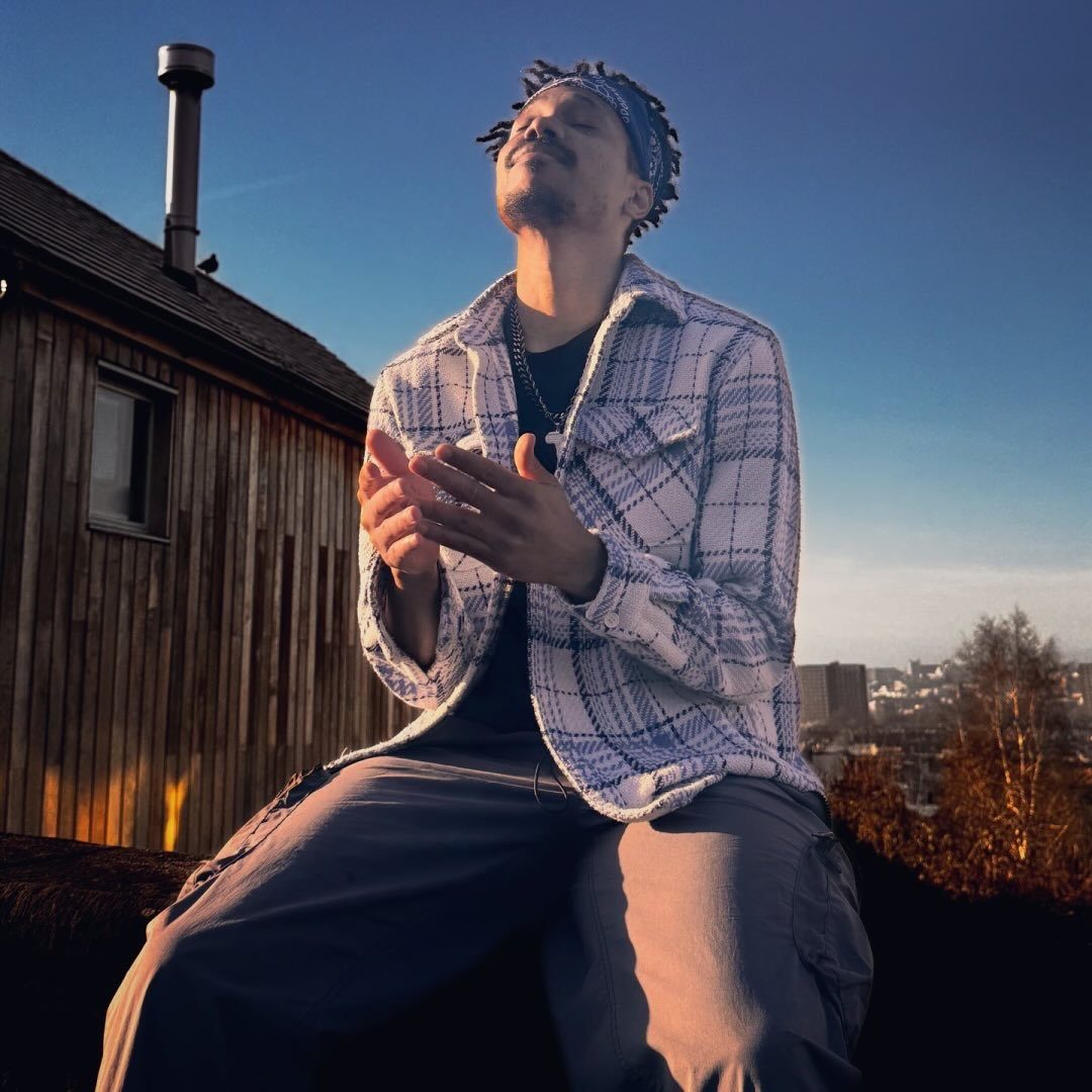 A person sits in the evening winter sun looking calm and meditative.