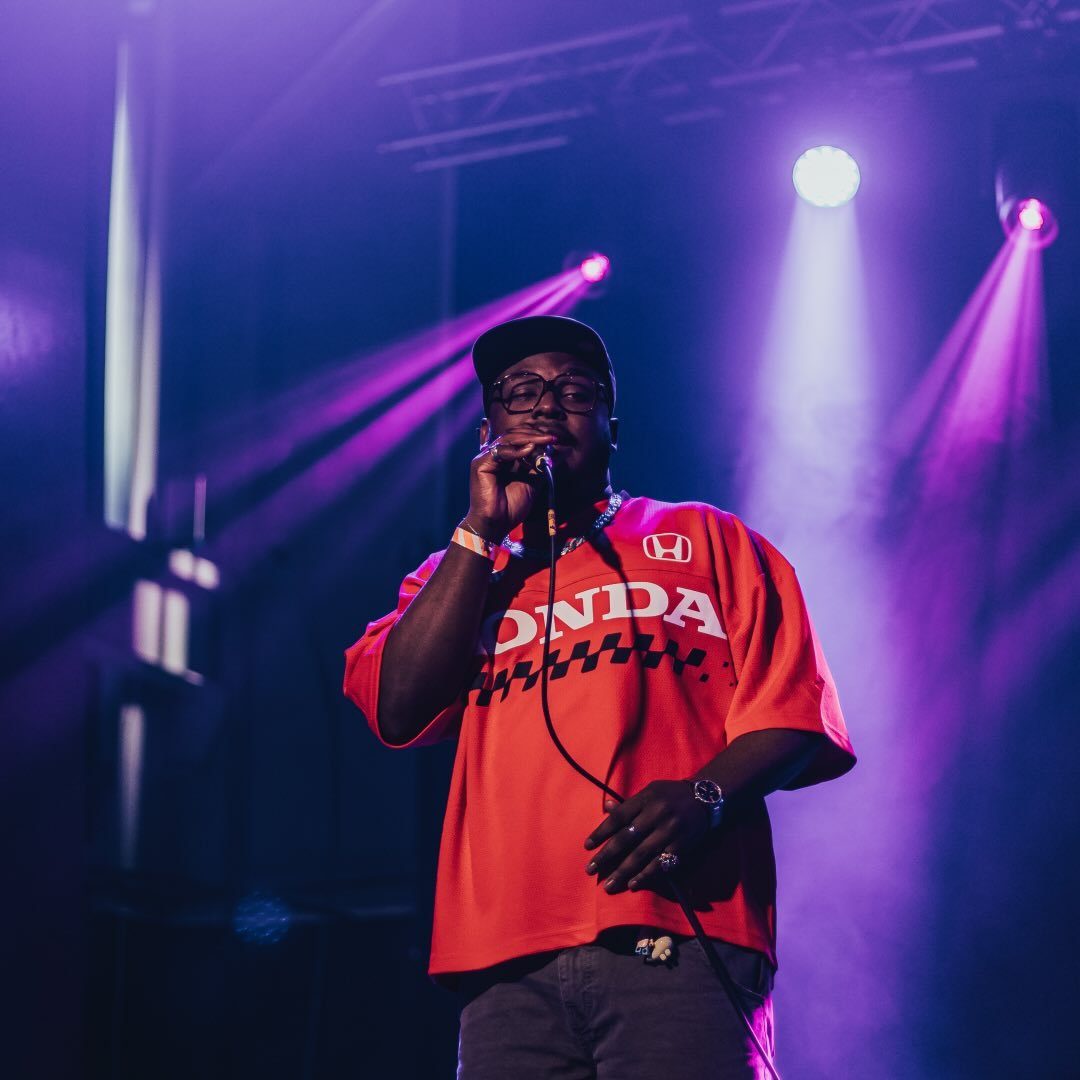 A musician wearing a red shirt with the words 