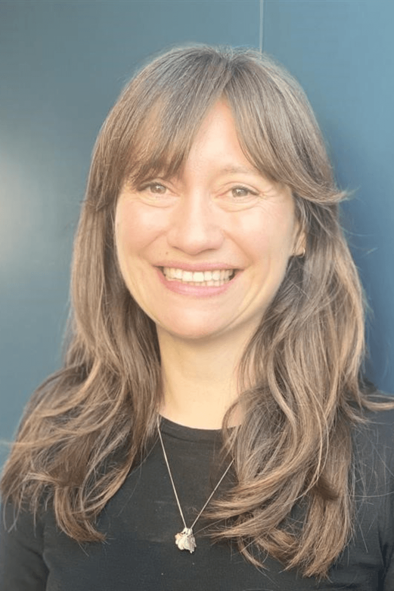 A person with long brown hair smiling.