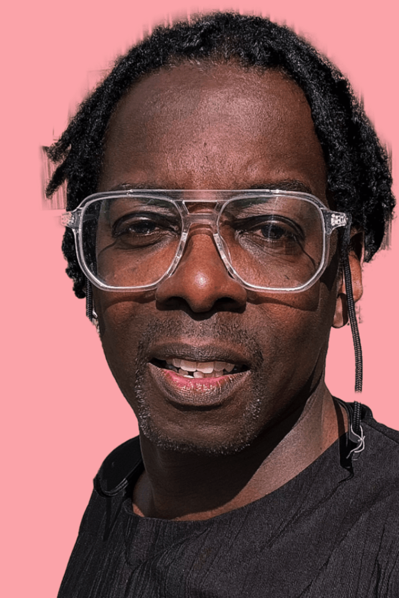 A person with short black hair wearing large transparent glasses